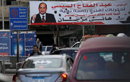 People walk near a poster of Egypt's President Abdel Fattah al-Sisi that reads "we've chosen you for a second term" in Cairo, Egypt January 15, 2018. Picture taken January 15, 2018. REUTERS/Mohamed Abd El Ghany