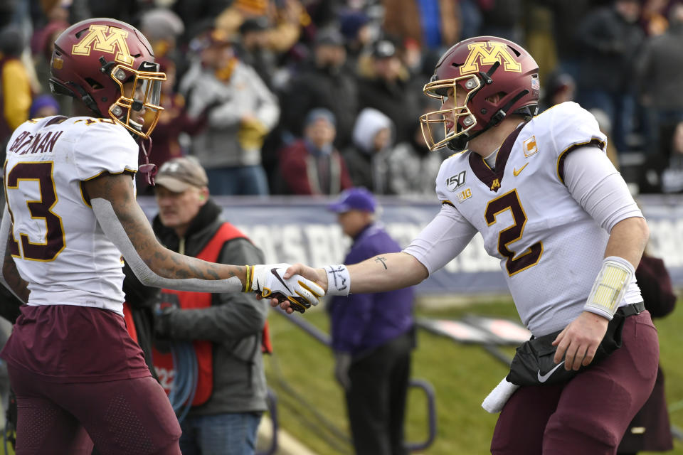 Minnesota wide receiver Rashod Bateman (13) celebrates with quarterback Tanner Morgan (2) after catching a touchdown pass during the second half of an NCAA football game against Northwestern Saturday, Nov. 23, 2019, in Evanston, Ill. Minnesota won 38-22. (AP Photo/Paul Beaty)