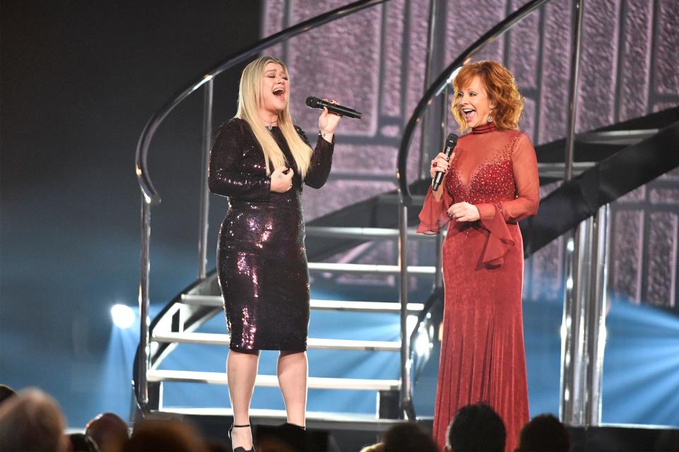 Kelly Clarkson, left, and host Reba McEntire perform