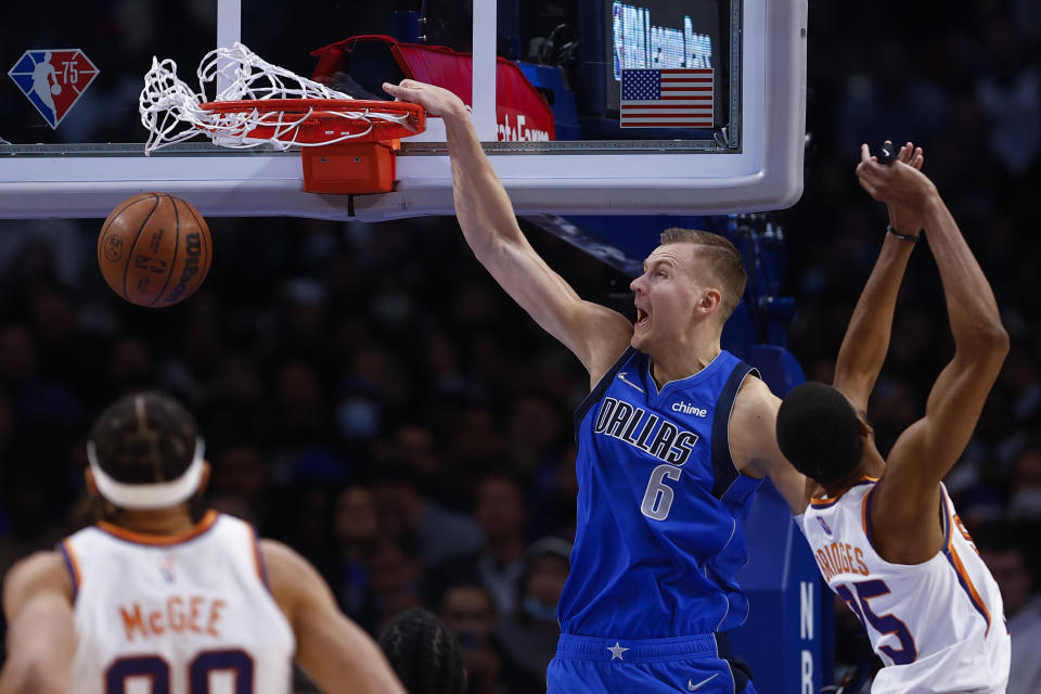 Dallas Mavericks forward Kristaps Porzingis (6) dunks as Phoenix Suns forward Mikal Bridges (25) defends during the first half of an NBA basketball game, Thursday, Jan. 20, 2022, in Dallas. (AP Photo/Brandon Wade)