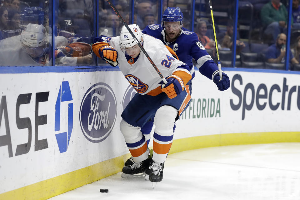 New York Islanders defenseman Scott Mayfield (24) moves the puck in front of Tampa Bay Lightning center Steven Stamkos (91) during the second period of an NHL hockey game Monday, Dec. 9, 2019, in Tampa, Fla. (AP Photo/Chris O'Meara)