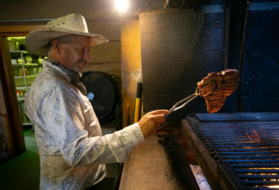 Chef Randy Culling grills a T Bone steak over a mesquite fire at the T Bone Steakhouse in Phoenix on June 29, 2021. 