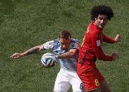 Belgium's Marouane Fellaini (R) fights for the ball with Argentina's Lucas Biglia during their 2014 World Cup quarter-finals at the Brasilia national stadium in Brasilia July 5, 2014. REUTERS/David Gray