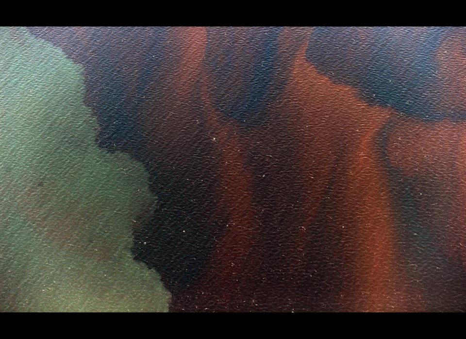 Mississippi River water (L) meets sea water and an oil slick that has passsed inside of the protective barrier formed by the Chandeleur Islands, as cleanup operations continue for the BP Deepwater Horizon platform disaster off Louisiana, on May 7, 2010. The Gulf of Mexico oil slick threatens disaster for the fragile US coast, causing clean-up efforts to focus on the best of a bad set of options: fight it there before it arrives here. An army of workers hired by British Petroleum, along with the US Coast Guard and local officials in Louisiana, have rushed to set out protective booms, spread dispersants and burn the oil when they can as it moves toward the shore. The strategy is to deal with the growing slick as much as possible before it laps into wetlands on Louisiana's coast, where its effects could be catastrophic and cleaning it is infinitely more difficult if not impossible.                 AFP PHOTO/Mark RALSTON (Photo credit should read MARK RALSTON/AFP/Getty Images)