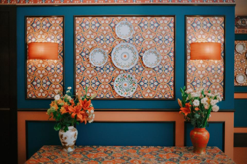 a group of flowers in front of a wall with art