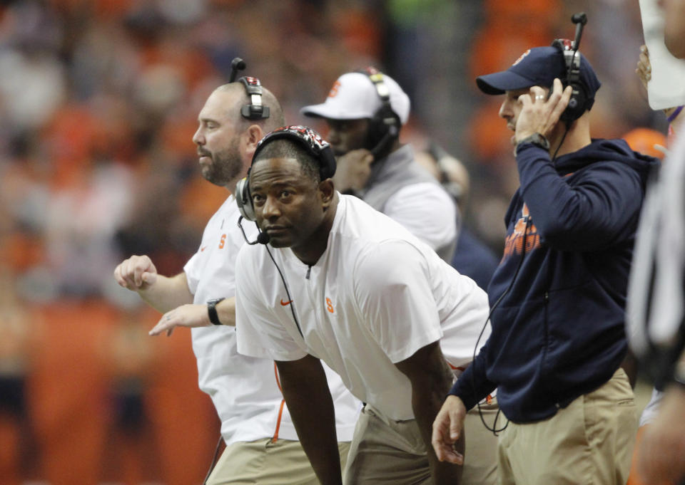 Syracuse coach Dino Babers, center, looks at the clock during the first quarter of the team's NCAA college football game against Pittsburgh in Syracuse, N.Y., Friday, Oct. 18, 2019. (AP Photo/Nick Lisi)
