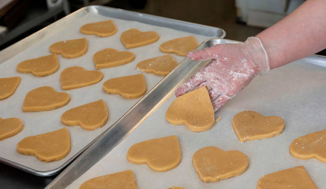 Annelee Giese of Rise & Shine Bake Shop in downtown Kennewick prepares heart-shaped sugar cookies in this file photo.