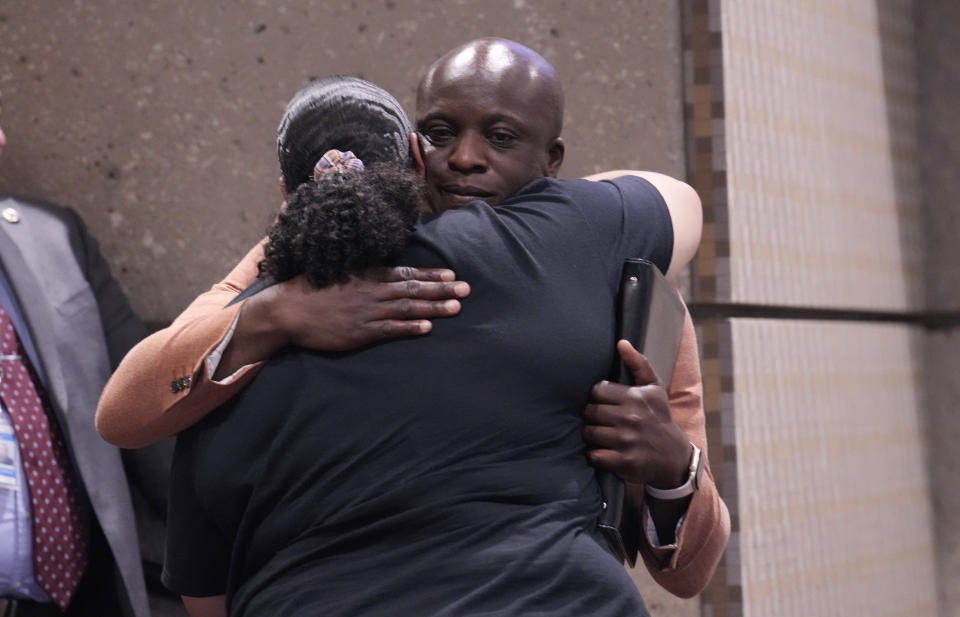 Colorado Springs, Colo., Mayor Yemi Mobolade, back, consoles Adriana Vance, who lost her son in the massacre at Club Q in November 2022, during a news conference after a hearing for the shooting suspect Monday, June 26, 2023, in Colorado Springs, Colo. The suspect pleaded guilty in the attack that left five people dead and wounded multiple others just before Thanksgiving Day 2022, at the longtime sanctuary for the LGBTQ+ community in this mostly conservative city. (AP Photo/David Zalubowski)