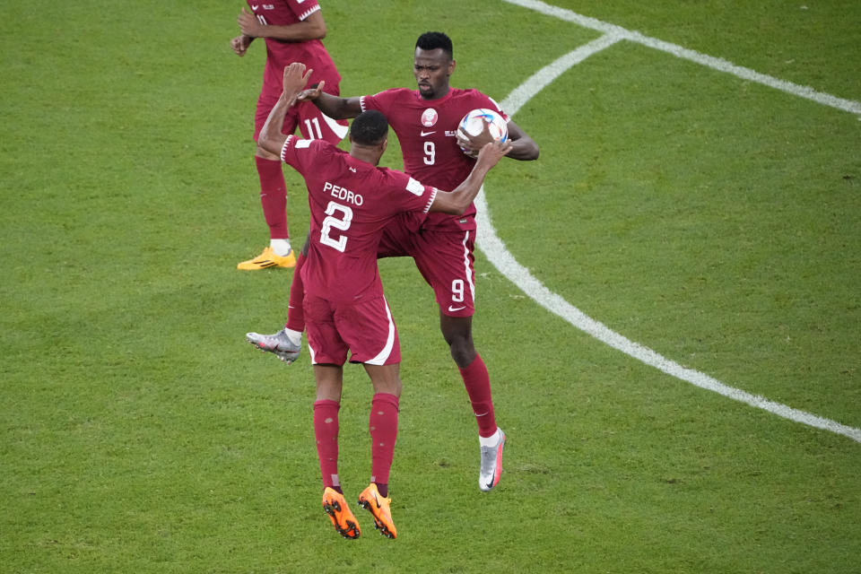 Qatar's Mohammed Muntari, right, celebrates with Pedro Miguel after scoring during the World Cup group A soccer match between Qatar and Senegal, at the Al Thumama Stadium in Doha, Qatar, Friday, Nov. 25, 2022. (AP Photo/Ariel Schalit)
