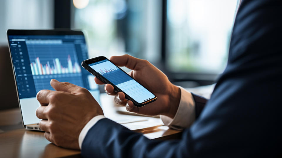 A customer using their mobile device to access financial services with the help of a customer service representative.