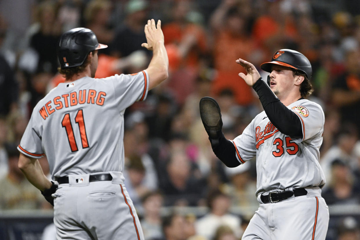 Adley Rutschman (35) of the Baltimore Orioles, right, is congratulated by Jordan Westburg (11) after scoring during the fifth inning on Monday at San Diego. (Photo by Denis Poroy/Getty Images)
