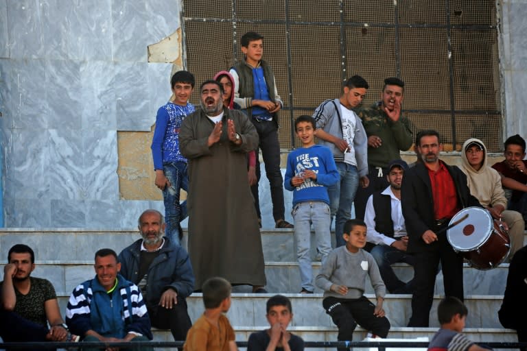 Syrians watch a football match on April 16, 2018 between local teams at a stadium in Raqa that the Islamic State group once used as a prison