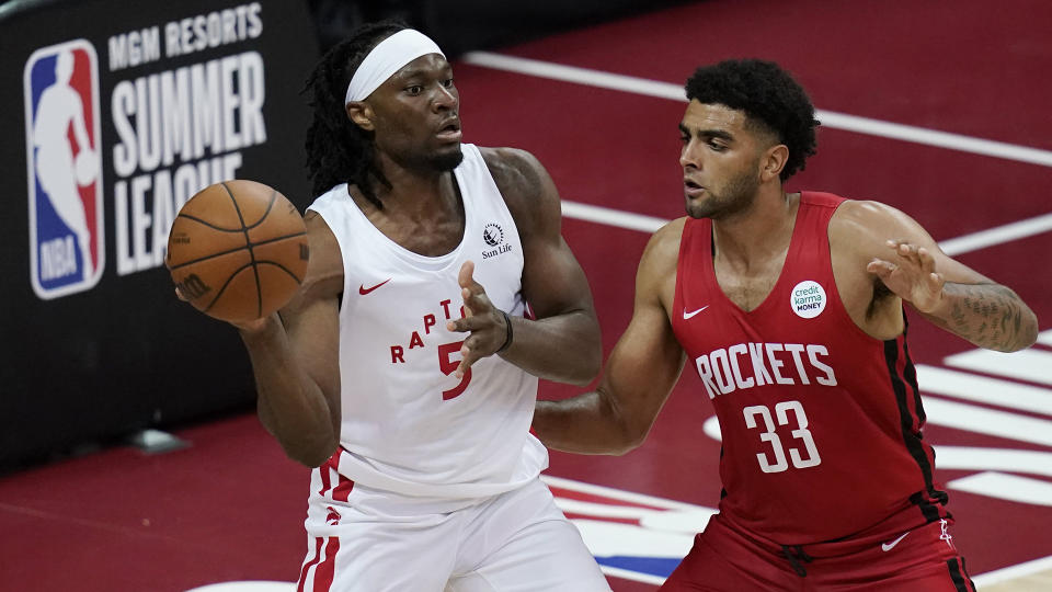 Toronto Raptors' Precious Achiuwa passes around Houston Rockets' Anthony Lamb during the second half of an NBA summer league basketball game Thursday, Aug. 12, 2021, in Las Vegas. (AP Photo/John Locher)