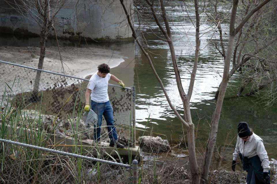 Volunteers, including Johansen High junior Jesus Atayde, left, clean up trash as part of the Operation 9-2-99 river clean-up along the Tuolumne River in Modesto, Calif., Saturday, March 9, 2024.