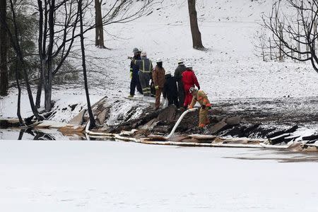 Responders throw oil booms into the Kanawha River near Mount Carbon, West Virginia, Tuesday, February 17, 2015. REUTERS/Marcus Constantino