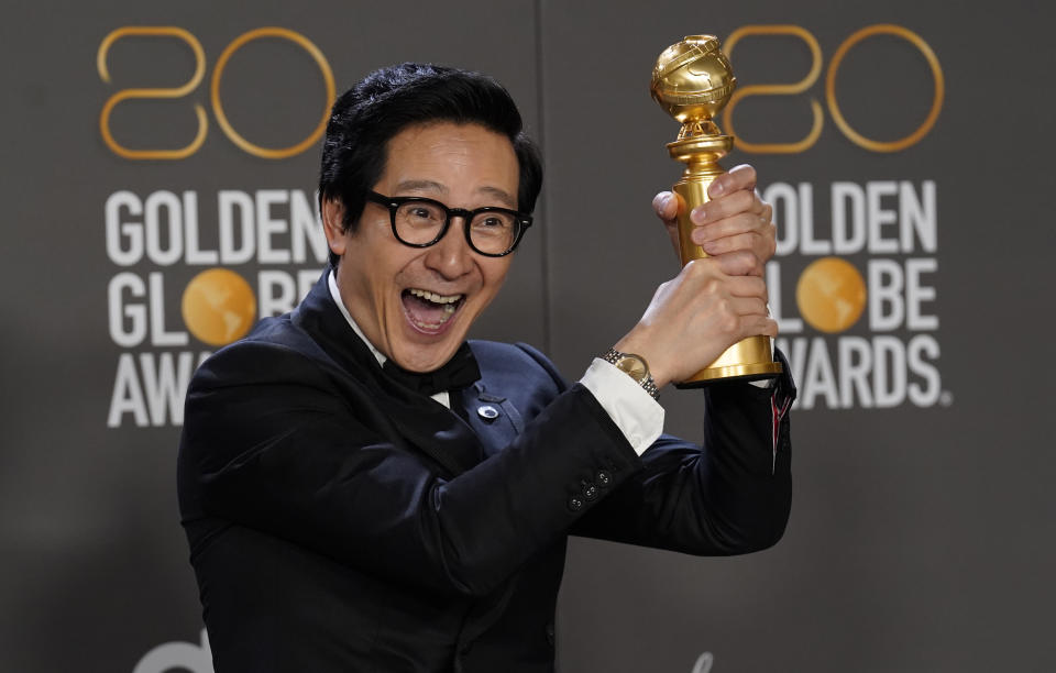Ke Huy Quan poses in the press room with the award for best performance by an actor in a supporting role in any motion picture for 
