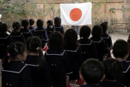 Students line up in front of JapanÕs national flag at the morning assembly at Tsukamoto kindergarten in Osaka, Japan, November 30, 2016. REUTERS/Ha Kwiyeon/Files