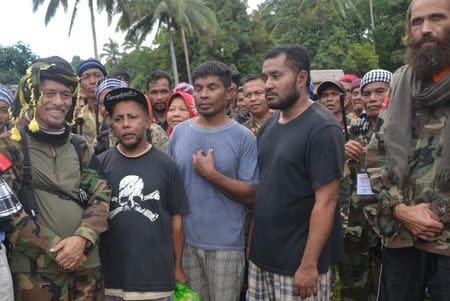 Three Indonesian nationals and Norwegian national Kjartan Sekkingstad (R) stand next to Moro National Liberation Front (MNLF) leader Nur Misuari and other members of the rebel group after the hostages are freed from the al Qaeda-linked Abu Sayyaf Islamist militant group, in Jolo, Sulu in southern Philippines September 18, 2016. REUTERS/Nickie Butlangan