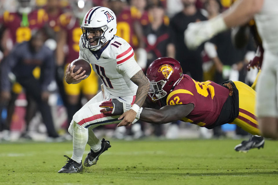 Arizona quarterback Noah Fifita (11) is tackled by Southern California defensive lineman Kyon Barrs (92) during the second half of an NCAA college football game Saturday, Oct. 7, 2023, in Los Angeles. (AP Photo/Marcio Jose Sanchez)