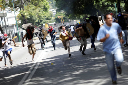 Demonstrators run away at a rally during a strike called to protest against Venezuelan President Nicolas Maduro's government in Caracas. REUTERS/Ueslei Marcelino