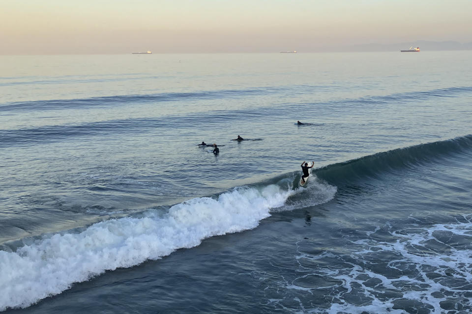 Surfers catch the sunrise swell at Manhattan Beach, Calif., on Monday, Sept. 5, 2022, as a severe heat wave gripped the state. (AP Photo/John Antczak)