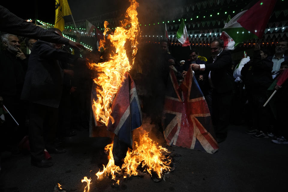 Iranian protesters burn representations of the British flag during their anti-Israeli gathering to condemn killing members of the Iranian Revolutionary Guard in Syria, at the Felestin (Palestine) Sq. in downtown Tehran, Iran, Monday, April 1, 2024. An Israeli airstrike that demolished Iran's consulate in Syria killed two Iranian generals and five officers, Syrian and Iranian officials said Monday. (AP Photo/Vahid Salemi)