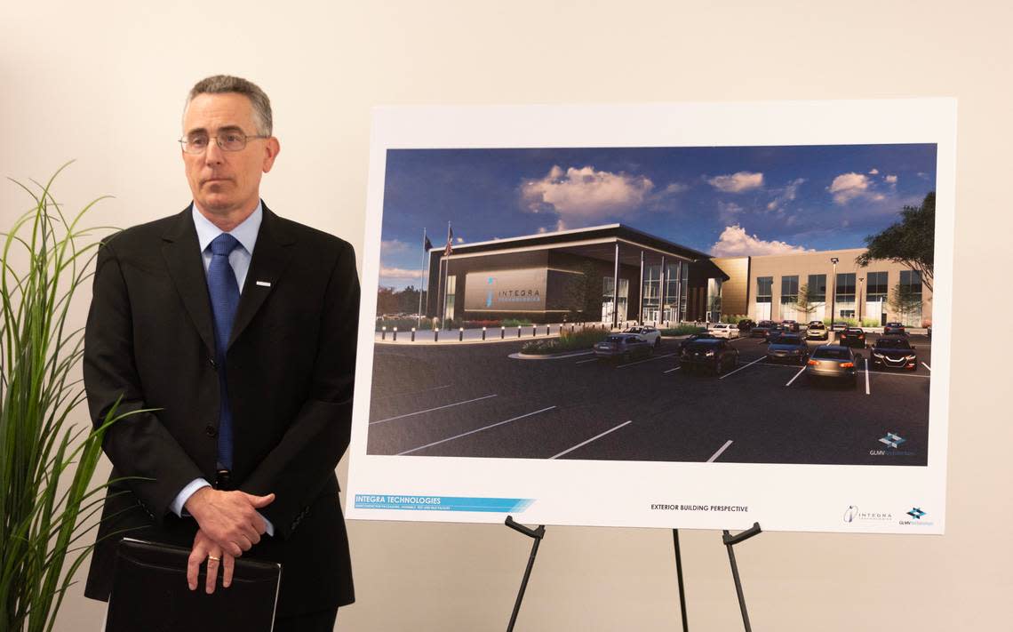 Brett Robinson, the president and CEO of Integra Technologies, stands next to a rendering of Intergra’s new manufacturing facility that will be constructed near north Rock Road and Highway 254.