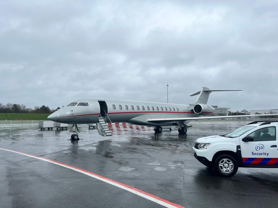 A VistaJet Bombardier Global 7500 with tail number 9H-VIC parked on the rainy tarmac at Farnborough Airport.