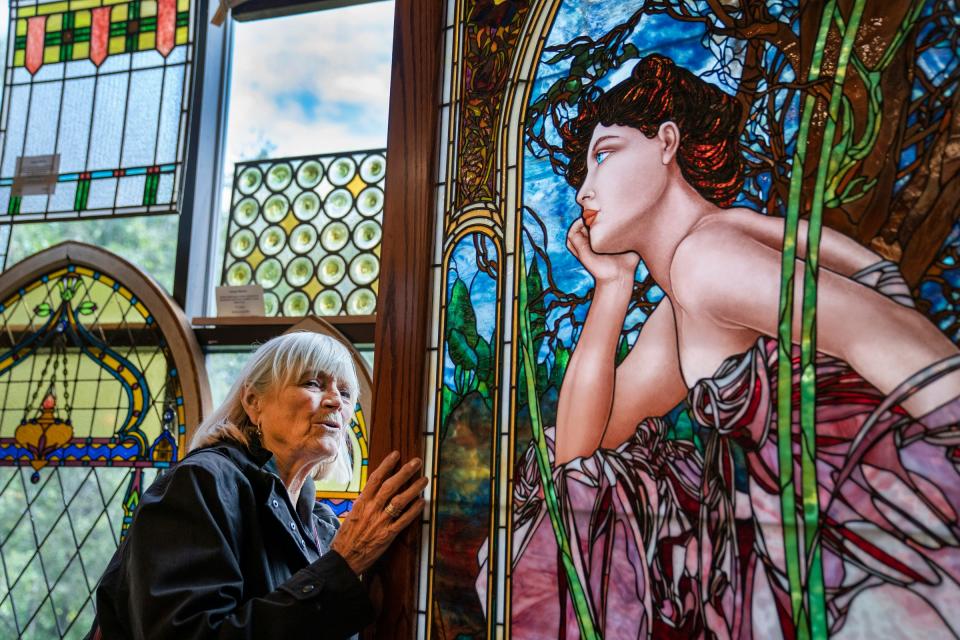 Sally Szilagyi, 79, of Saline loves stained glass as she looks over a large stained glass panel in the Materials Unlimited antique store in Ypsilanti on Sept. 28, 2022. After 50 years in business, the store will be closing this winter.