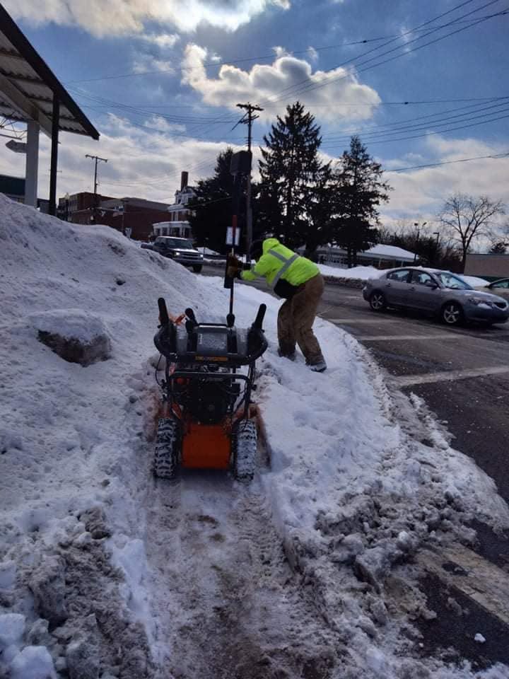Dom Black clears snow on a sidewalk in Alliance after heavy snowfall.