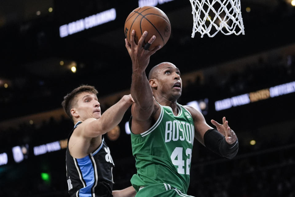 Boston Celtics center Al Horford (42) is fouled by Atlanta Hawks guard Bogdan Bogdanovic (13) as he goes in for a shot during the second half of an NBA basketball game Monday, March 25, 2024, in Atlanta. (AP Photo/John Bazemore)
