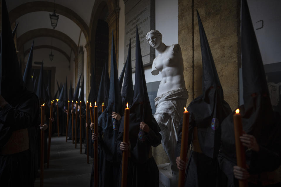 Penitents of "Los Estudiantes" brotherhood gather in one of the courtyards of the University of Seville before starting the procession, Spain, Tuesday, April 4, 2023. Hundreds of processions take place throughout Spain during the Easter Holy Week. (AP Photo/Emilio Morenatti)