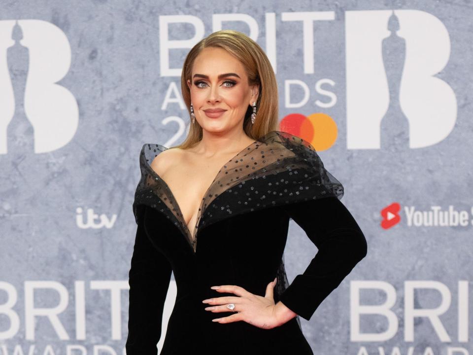 Adele in refined makeup and a black tulle top dress.