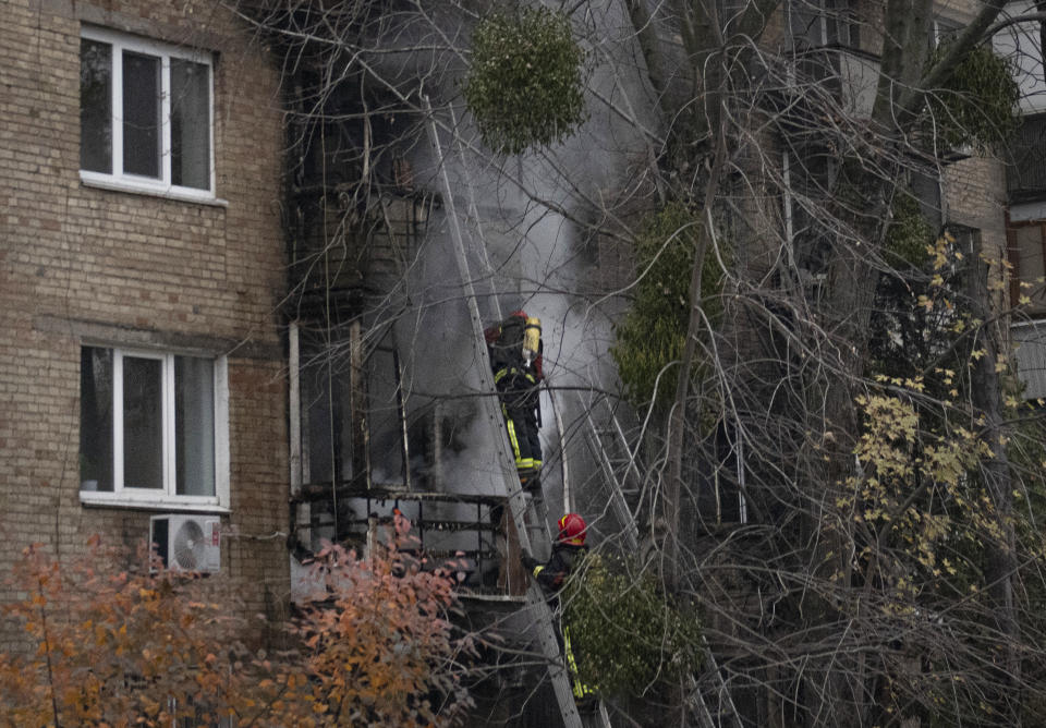 Ukrainian State Emergency Service firefighters work to extinguish a fire at the scene of a Russian shelling in Kyiv, Ukraine, Tuesday, Nov. 15, 2022. Strikes hit residential buildings in the heart of Ukraine's capital Tuesday, authorities said. Further south, officials announced probes of alleged Russian abuses in the newly retaken city of Kherson, including torture sites and enforced disappearances and detentions. (AP Photo/Andrew Kravchenko)