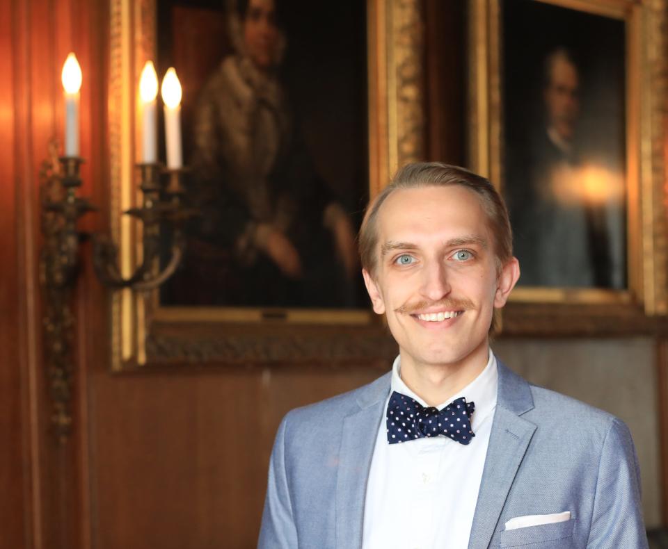 Zachary Veith, the historical interpreter at Staatsburg State Historic Site, stands beside portraits of the Lewis family on March 2. Veith has been researching the Lewis family, who established the estate in Staatsburg and owned slaves until abolition became law in New York State in 1827.