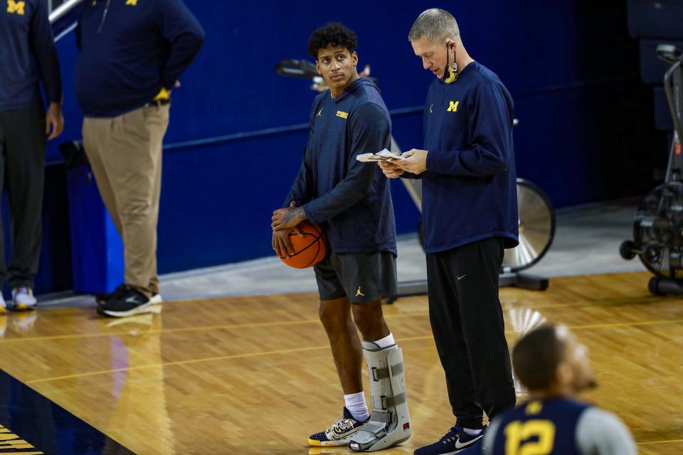 Michigan basketball senior Eli Brooks watches practice from the sideline, wearing a boot on his foot, during media day Oct. 15, 2021 at Crisler Center in Ann Arbor. Brooks was injured in a game last spring and has not returned.