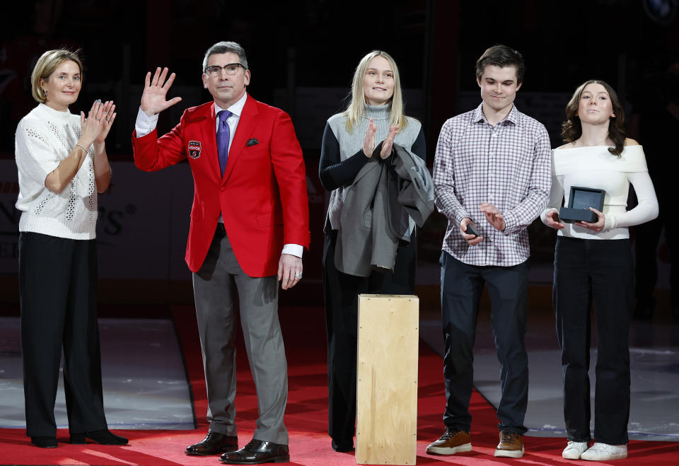 Devils Ring of Honor inductee Sergei Brylin, with his family, waves to fans during Ring of Honor ceremony before an NHL hockey game against the Dallas Stars, Saturday, Jan. 20, 2024, in Newark, N.J. (AP Photo/Noah K. Murray)