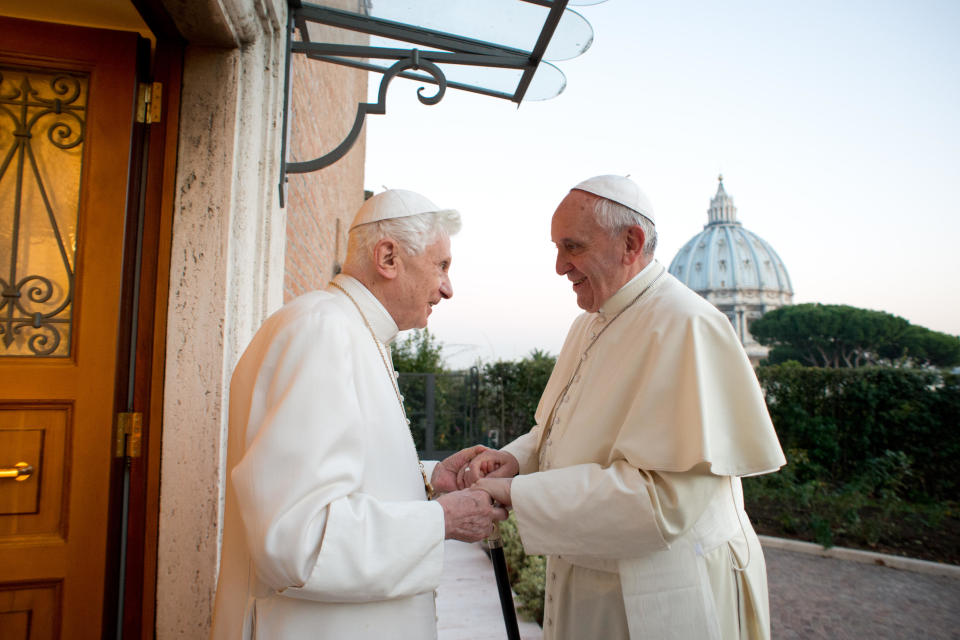 FILE -- In this Dec. 23, 2013 picture provided by the Vatican newspaper L'Osservatore Romano, Pope Emeritus Benedict XVI, left, welcomes Pope Francis as they exchanged Christmas greetings, at the Vatican. When Pope Benedict XVI abdicated, he insisted he would remain "hidden from the world" in prayer. But Francis has slowly coaxed him out of retirement and giving him an increasily public role in the church, believing that he like all elderly have something to offer and shouldn't be holed up in a museum like a "statue." (AP Photo/L'Osservatore Romano, ho)