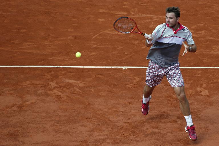 Switzerland's Stanislas Wawrinka returns to Switzerland's Roger Federer during their men's quarter final match of the Roland Garros 2015 French Tennis Open in Paris on June 2, 2015