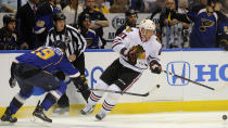 Chicago Blackhawks' Marian Hossa (81), of Sweden, and St. Louis Blues' Jay Bouwmeester (19) reach for a loose puck during the first period in Game 2 of a first-round NHL hockey playoff series on Saturday, April 19, 2014, in St. Louis. (AP Photo/Bill Boyce)