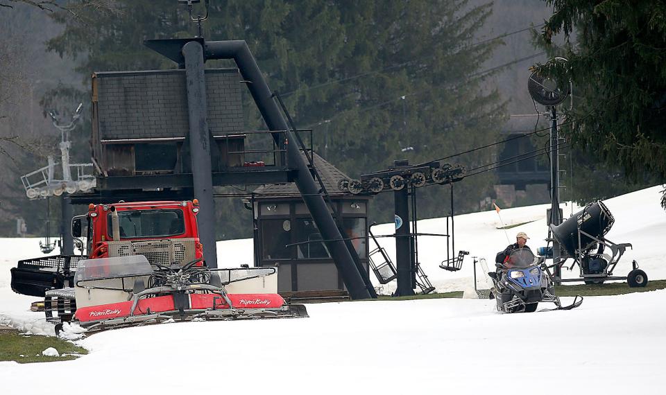 Snow Trails employees on Thursday work to get the slopes in condition for their opening on Friday.