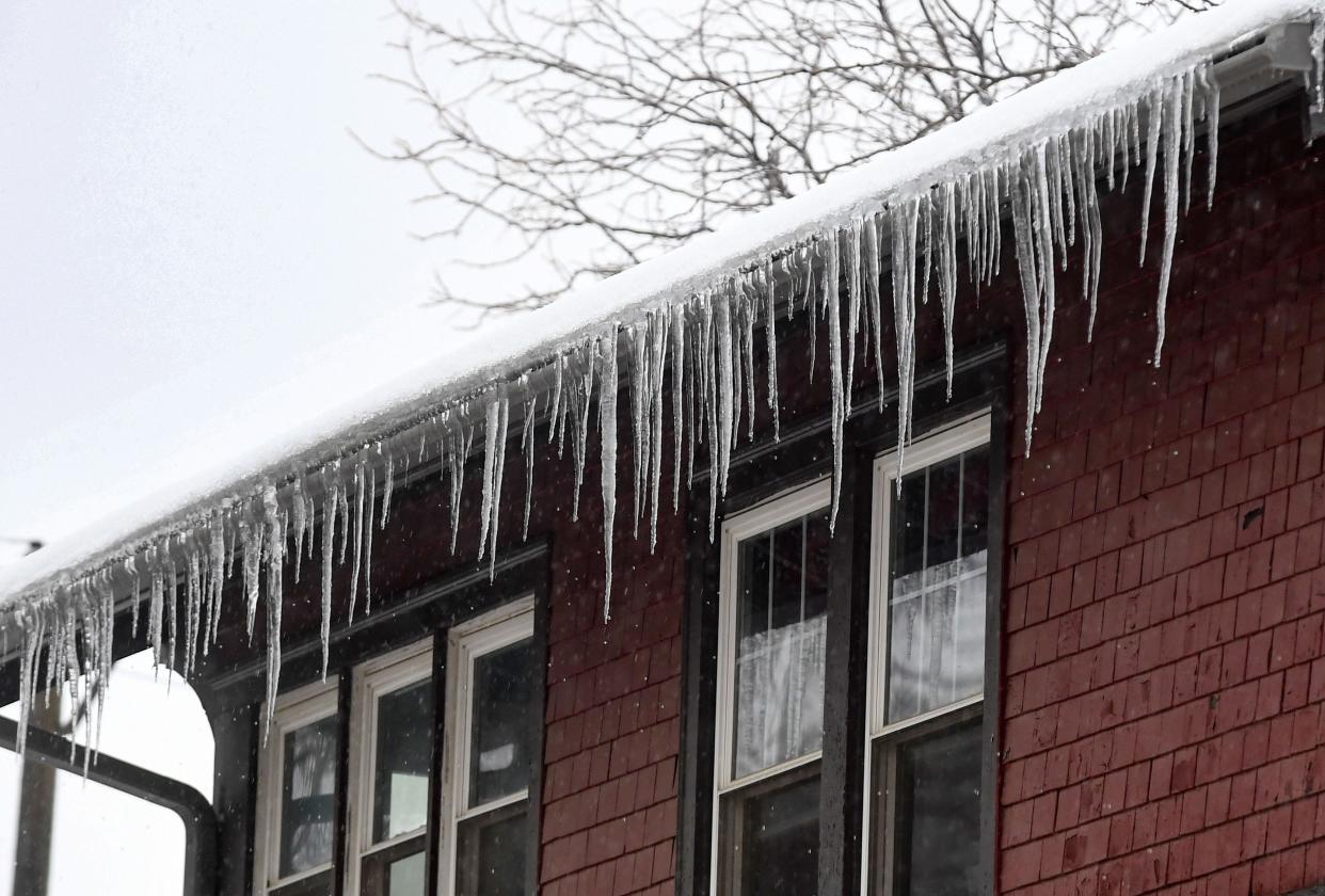 Icicles hang from a roof as rain from a winter storm creates icy conditions on Tuesday, December 13, 2022, in Sioux Falls, SD.