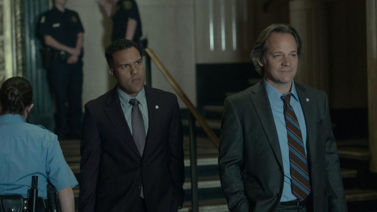 a couple of men in suits walking down a flight of stairs