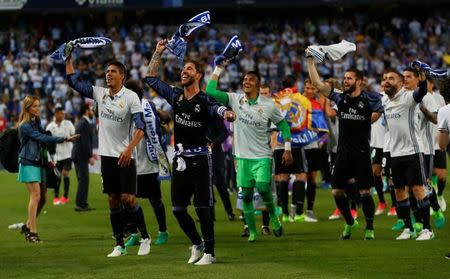 Foto del domingo de los defensores del Real Madrid Sergio Ramos y Raphael Varane celebrando el título de la liga española de fútbol. 21/5/17 El Real Madrid conquistó el domingo la liga española de fútbol por primera vez desde la temporada 2011-12 con una victoria 2-0 como visitante sobre el Málaga con tantos de Cristiano Ronaldo y Karim Benzema. Reuters / Juan Medina