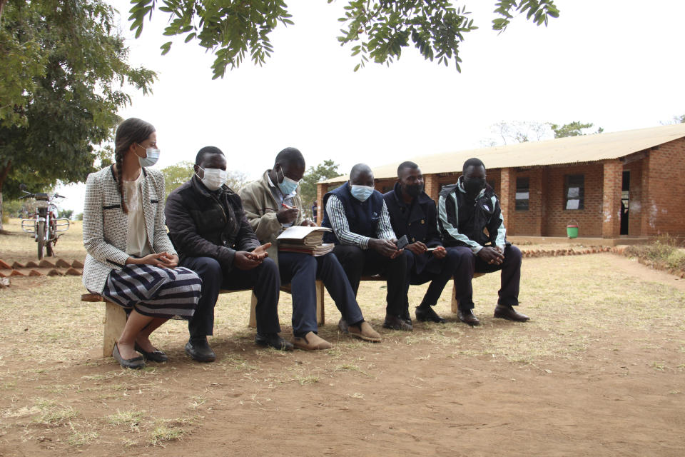 Cameron Beach, sits with fellow teachers during a break at a school in Dedza, near Lilongwe, Malawi, Friday, July 23, 2021. Beach, a former Peace Corps volunteer, is living in rural Malawi teaching English at a rural high school where she had been sent by the United States government 18-months before COVID-19 began sweeping the world. (AP Photo/Roy Nkosi)