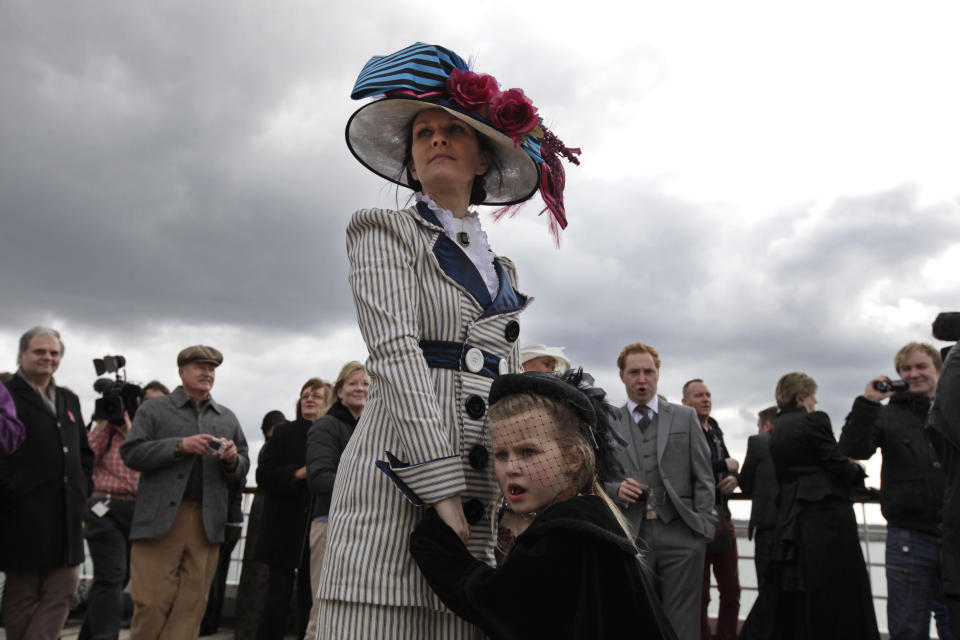 In this photo taken Sunday, April 8, 2012, wearing period costumes, British passenger Jacki Free holds her daughter, name not given, as the MS Balmoral Titanic memorial cruise ship sails from Southampton, England. A cruise carrying relatives of some of the more than 1,500 people who died aboard the Titanic nearly 100 years ago set sail from England on Sunday to retrace the ship's voyage, including a visit to the location where it sank. (AP Photo/Lefteris Pitarakis)