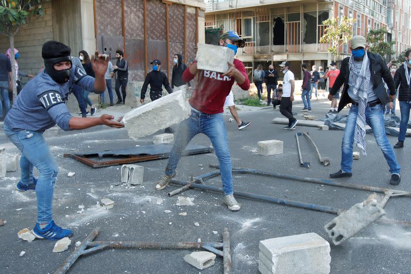 Demonstrators throw pieces of concrete during a protest against growing economic hardship in Beirut