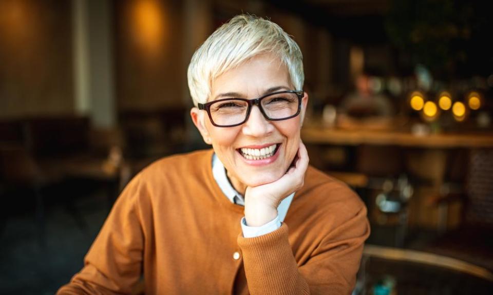 Portrait of a beautiful smiling senior woman with short hair. She is looking to camera