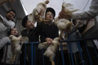 FILE - Ultra-Orthodox Jewish men buy chickens to perform the Kaparot ritual in Bnei Brak near Tel Aviv, Israel, Monday, Oct. 3, 2022, before the Day of Atonement, Yom Kippur, the holiest day in the Jewish year which starts at sundown Tuesday. Yom Kippur involves a 25-hour fasting period that’s coupled with prayers for forgiveness. (AP Photo/Oded Balilty, File)