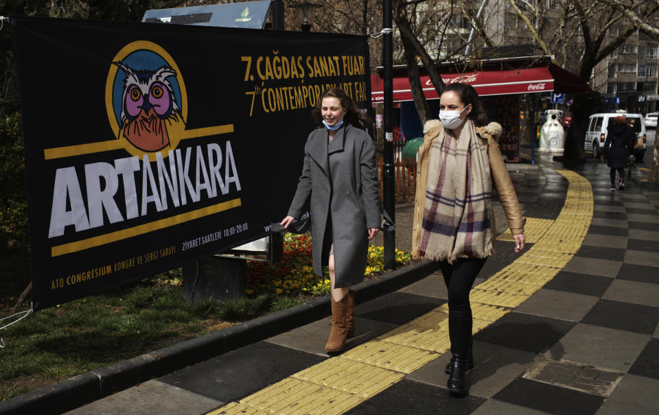 Women walk along a popular street, in Ankara, Turkey, Monday, March 22, 2021. Daily COVID-19 infections in Turkey surged above 26,000, weeks after the government eased restrictions in dozens of provinces under a so-called "controlled normalization" program. The Health Ministry reported a total of 26,182 new infections on Tuesday March 23, a level previously seen in December 2020. (AP Photo/Burhan Ozbilici)